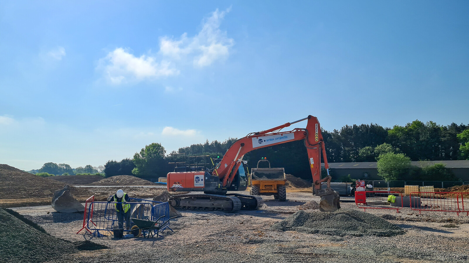 Construction site with an Entex Projects excavator and a blue sky