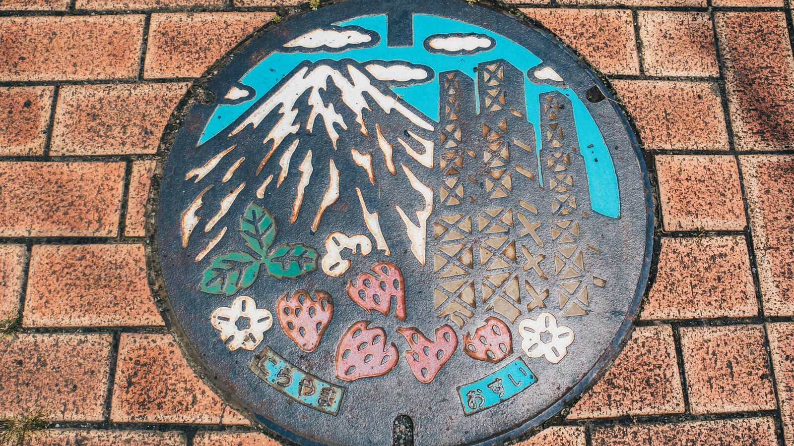 Japanese manhole cover with strawberries and mountain art