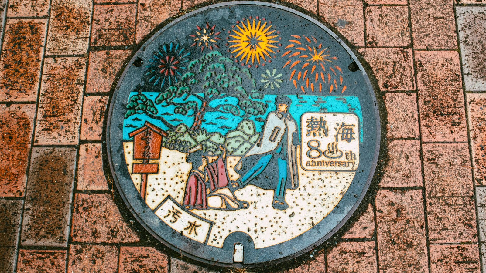 Japanese manhole cover with traditional person and sun