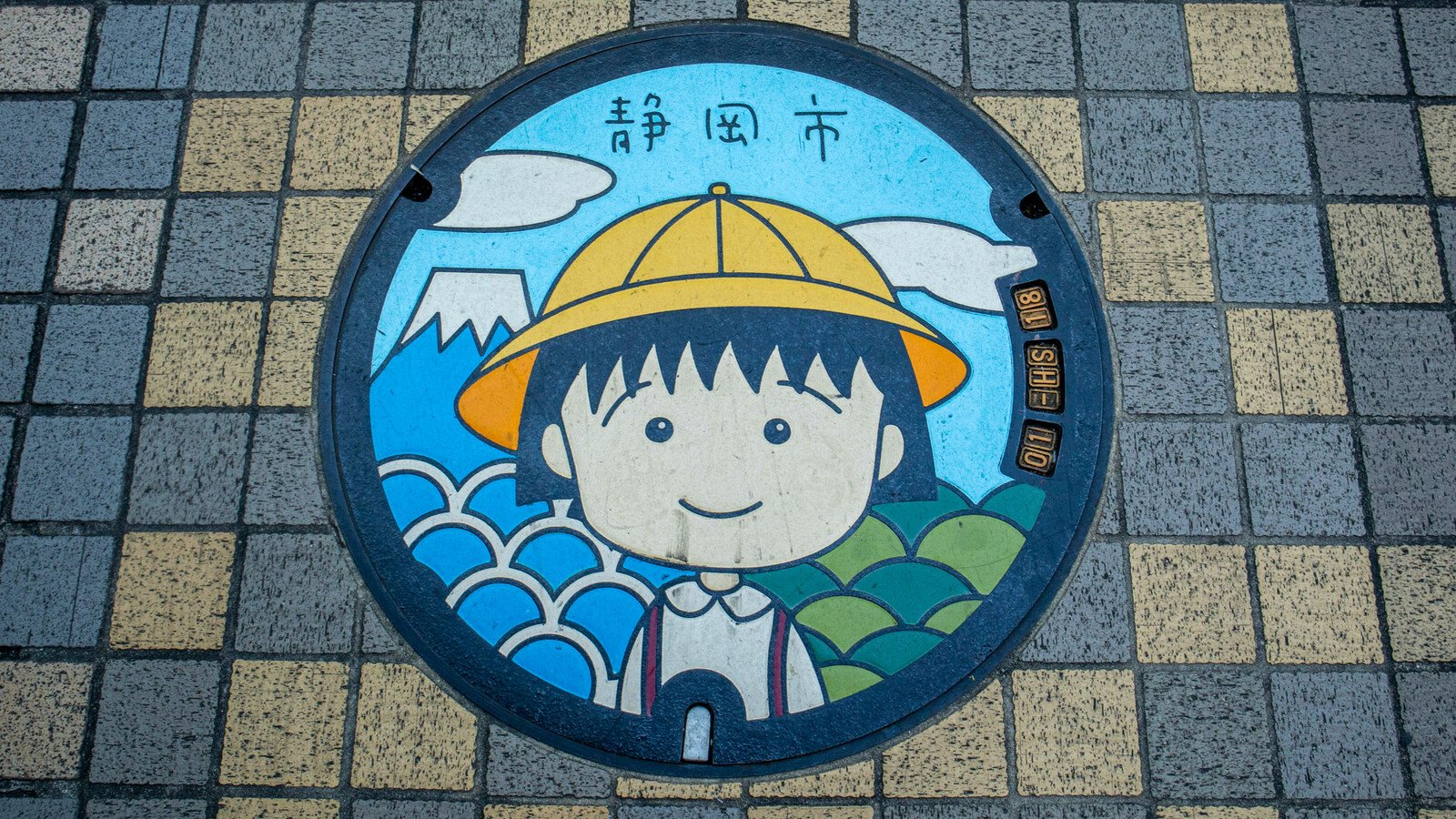 Japanese manhole cover with cartoon girl art