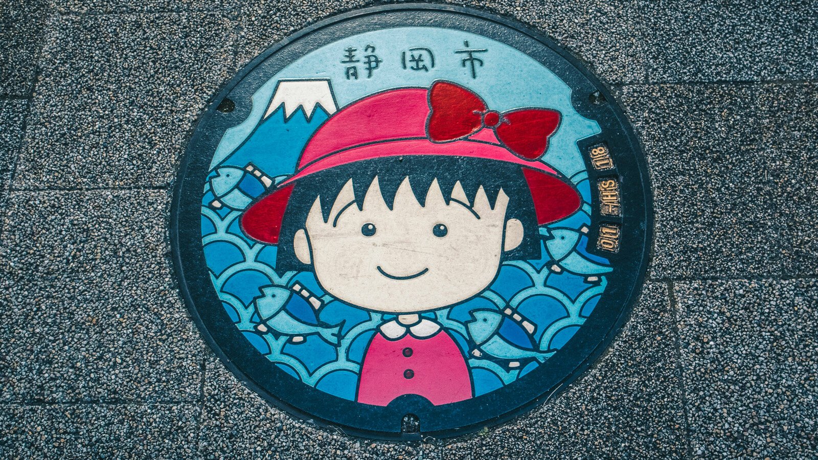 Japanese manhole cover with cartoon girl and mountain art