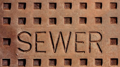 sewer rust stencil word manhole cover