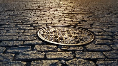 old manhole cover cobbled street
