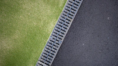 linear channel drain between tarmac and astroturf surfaces